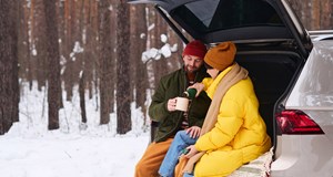 man and woman in the car in snow