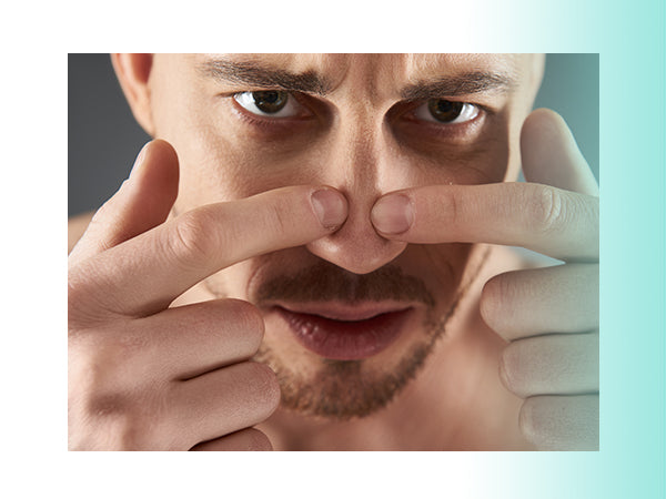 Man Applying Pressure to Pop Pimple on Nose