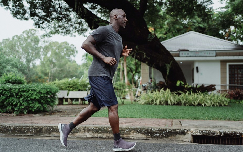 Person running down a street to boost their physical health