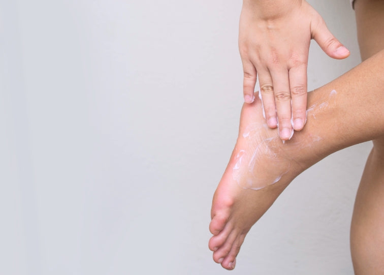 Putting lotion on foot