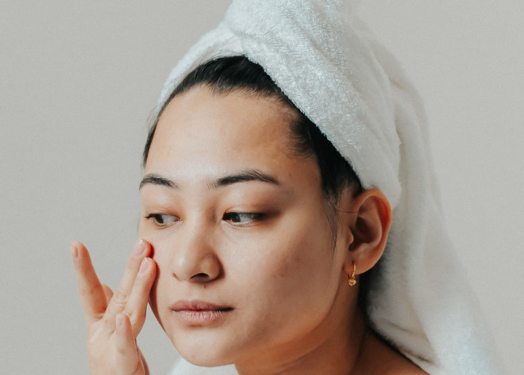 women touching face in hair towel